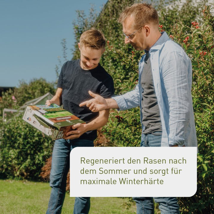 Vater und Sohn düngen Rasen im Herbst