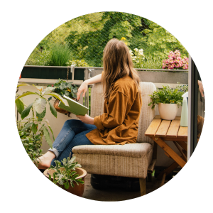 Frau liest auf Balkon mit Pflanzen