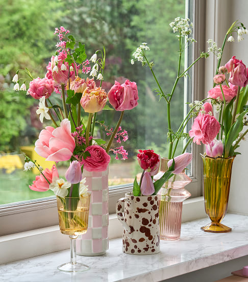 Rosa Schnittblumen in Vasen auf Fensterbank